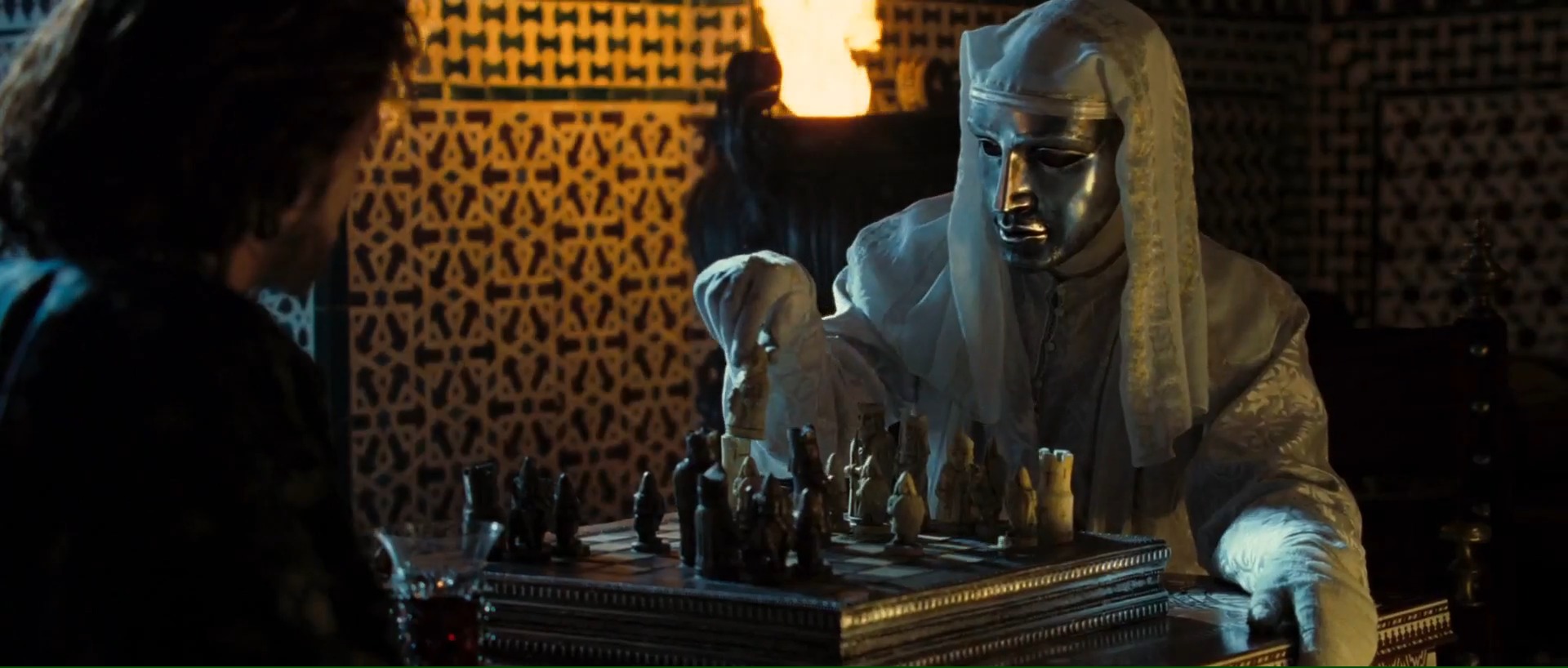 A masked King Baldwin IV, the leper king of Jerusalem, plays an intense chess match with Saladin’s envoy. This scene highlights the political intrigue and diplomatic tensions between the Kingdom of Jerusalem and the Ayyubid Sultanate, foreshadowing the impending conflict.