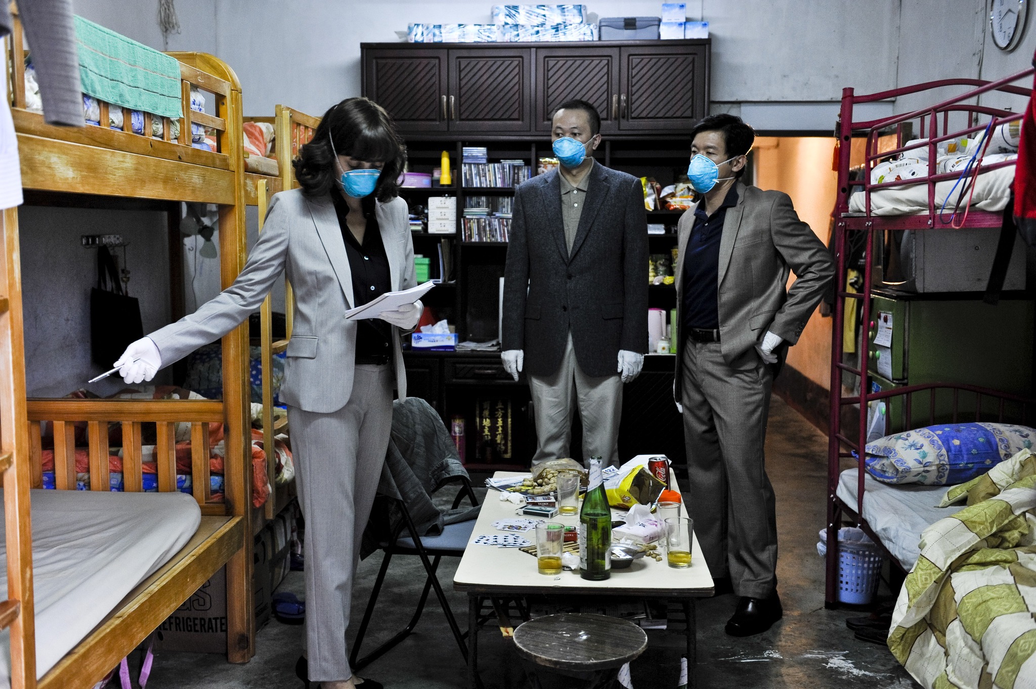 Marion Cotillard as Dr. Leonora Orantes leads an on-site investigation in Hong Kong in Contagion (2011). Wearing protective masks and gloves, she and local officials examine a dormitory linked to the outbreak’s origins.